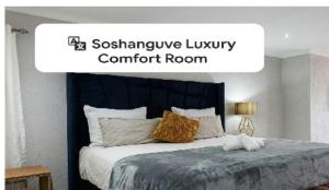 a bedroom with a bed with a blue headboard at Soshanguve Lux Accom Room 03 in Soshanguve