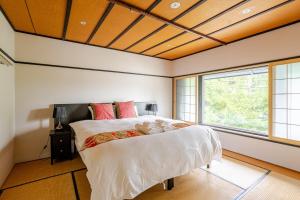 a bedroom with a large bed and a large window at Ski-in, Ski-out Iwatake Apartments in Hakuba