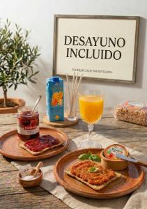 a table with two plates of pizza and a glass of orange juice at Apartalux Pax Palace in Las Negras