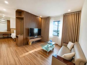 a living room with a couch and a television at Glory Hotel Apartment Hải Phòng in Hai Phong