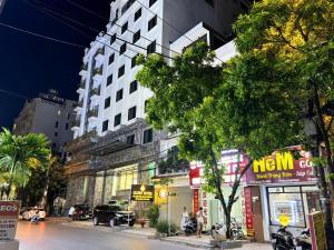 a city street at night with a tall building at Glory Hotel Apartment Hải Phòng in Hai Phong