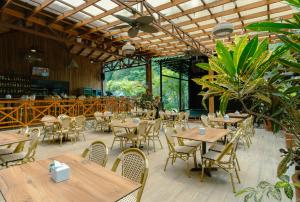 an empty restaurant with wooden tables and chairs at Bungalows Punta Uva in Puerto Viejo