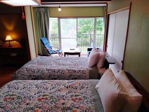 a hotel room with two beds and a window at ウテナ2 in Ito
