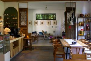 a restaurant with tables and chairs and a window at Yangshuo Shui Mo Ju courtyard-Yangshuo Raiway St'ation free pick up for two nights in Yangshuo