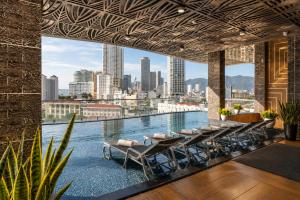 a pool with chairs and a view of the city at W Premium Nha Trang in Nha Trang