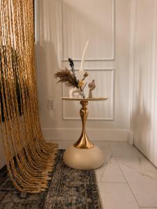 a gold table with a vase on it on a rug at Oasis on Monroe Aparthotel in Hollywood +31 photos
