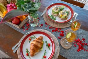 a table with two plates of food and fruit at Villas Shiva, Cahaya & Bulan Complex - Bingin, Uluwatu in Uluwatu