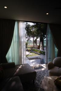 a living room with a couch and a large window at Padé Langkawi in Ulu Melaka +28 photos