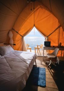 a bedroom with a bed and a desk in a tent at Reef Resort - Mount Apo View Unit C1 in Kaputian