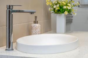 a white sink in a bathroom with a vase of flowers at The Deck in Elizabeth Beach +25 photos