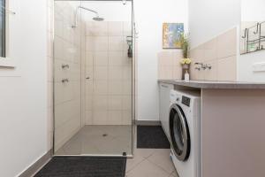 a bathroom with a shower and a washing machine at The Deck in Elizabeth Beach