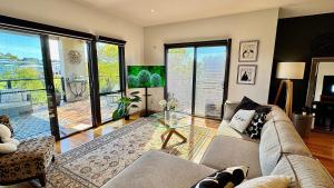 a living room with a couch and a table at Coastal Tones - Designer Beach house - Pets Welcome - Huge Yard - Walk to Beach in Cowes