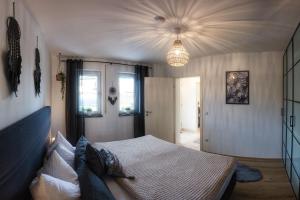 a bedroom with a bed and a chandelier at Ferienwohnung Kaiserblick in Anger