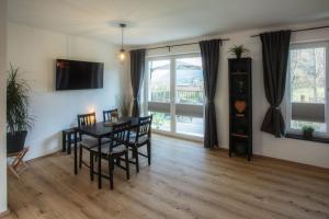 a living room with a table and chairs and a television at Ferienwohnung Kaiserblick in Anger