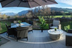 a deck with a table and chairs and an umbrella at Ferienwohnung Kaiserblick in Anger