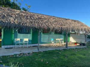 a hut with a table and chairs and a straw roof at Camping Hiva Plage in Parea