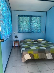 a blue bedroom with a bed and a window at Camping Hiva Plage in Parea