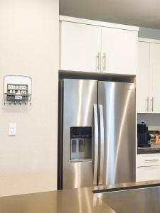a stainless steel refrigerator in a kitchen with white cabinets at Vip Class One Real Comfort 3 Bedrooms in Lodi