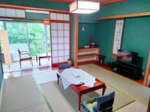 a living room with a table and a tv at ウテナ2 in Ito