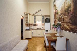 eine Küche und ein Esszimmer mit einem Tisch und einem Sofa in der Unterkunft Apartment Teatralnaya in Lwiw