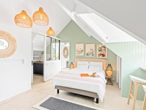 a bedroom with a white bed in a room at Shell Beach - Magnifique Loft sur la plage in Baie Nettle +19 photos