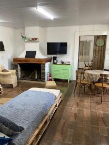 a living room with two beds and a table and a television at Sitio Piruetas in Santana do Livramento