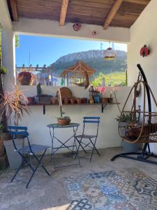 a patio with chairs and a table and a mural at Sitio Piruetas in Santana do Livramento