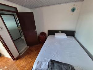 a small bedroom with a bed and a mirror at Hotel Típico Delphos in Filadelfia