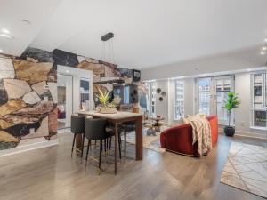 a dining room and living room with a stone wall at Regis Suites - Downtown Toronto in Toronto