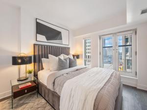 a bedroom with a large bed and a large window at Regis Suites - Downtown Toronto in Toronto