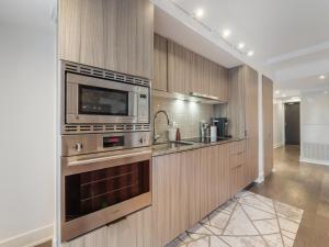 a kitchen with a stove and a microwave at Regis Suites - Downtown Toronto in Toronto +31 photos