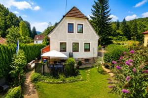 a white house with a yard with flowers at Zuhause am Bach Ruhige Unterkunft für Erholungssuchende am Welterbesteig und Donauradweg in Aggsbach