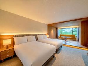 a hotel room with two beds and a window at UNWIND HOTEL & BAR Okunikko in Nikko