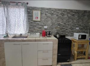 a kitchen with a stove and a sink and a counter at CATALINA in Neuquén