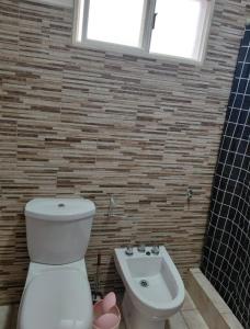 a bathroom with a toilet and a sink at CATALINA in Neuquén +1 photo