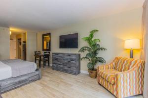 a bedroom with a bed and a tv and a chair at Landmark 618 in Myrtle Beach +48 photos