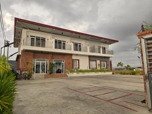 a building with a parking lot in front of it at MSD Resort Hotel in Bengcag