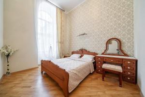 Schlafzimmer mit einem Bett, einer Kommode und einem Spiegel in der Unterkunft Apartment Teatralnaya in Lwiw