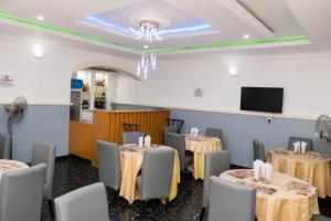a dining room with tables and chairs and a tv at Executive Private Bed and Bath in Otta