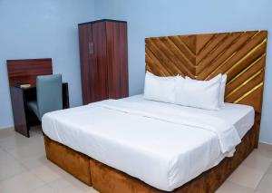 a bedroom with a large bed with a wooden headboard at Executive Private Bed and Bath in Otta +14 photos