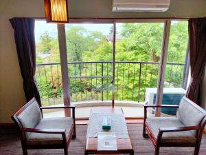 a room with a table and chairs and a large window at ウテナ2 in Ito +21 photos