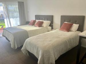 two beds sitting next to each other in a bedroom at Tripinn Botique Motels & Affordable Accommodation in Westport