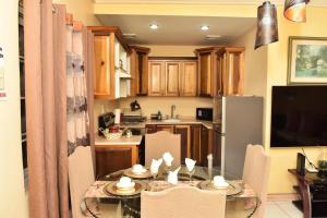 a kitchen with a table and chairs and a kitchen with a refrigerator at Embassy Royale in Kingston