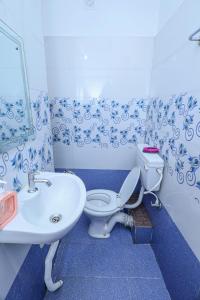 a blue and white bathroom with a toilet and a sink at Silver residency in Bhubaneshwar