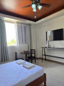 a bedroom with a bed and a ceiling fan at MSD Resort Hotel in Bengcag