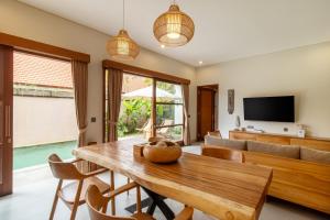 a living room with a wooden table and a couch at Coco Luxury Villas in Ubud
