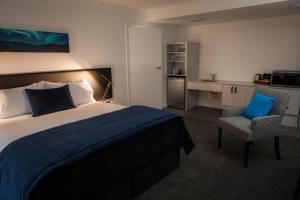 a hotel room with a bed and a chair at Aurora on George in Dunedin