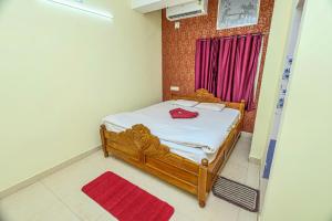 a bedroom with a bed with a red bag on it at Silver residency in Bhubaneshwar +10 photos