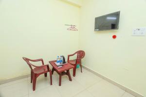 a table and two chairs and a tv on a wall at Silver residency in Bhubaneshwar