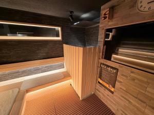 a small room with a wooden floor and a room with a door at HOTEL LiVEMAX BUDGET Hiratsuka Ekimae in Hiratsuka
